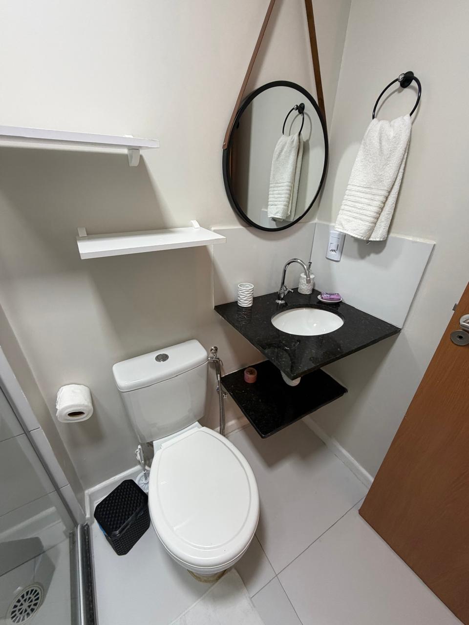 Lavabo do apartamento com espelho e bancada de granito