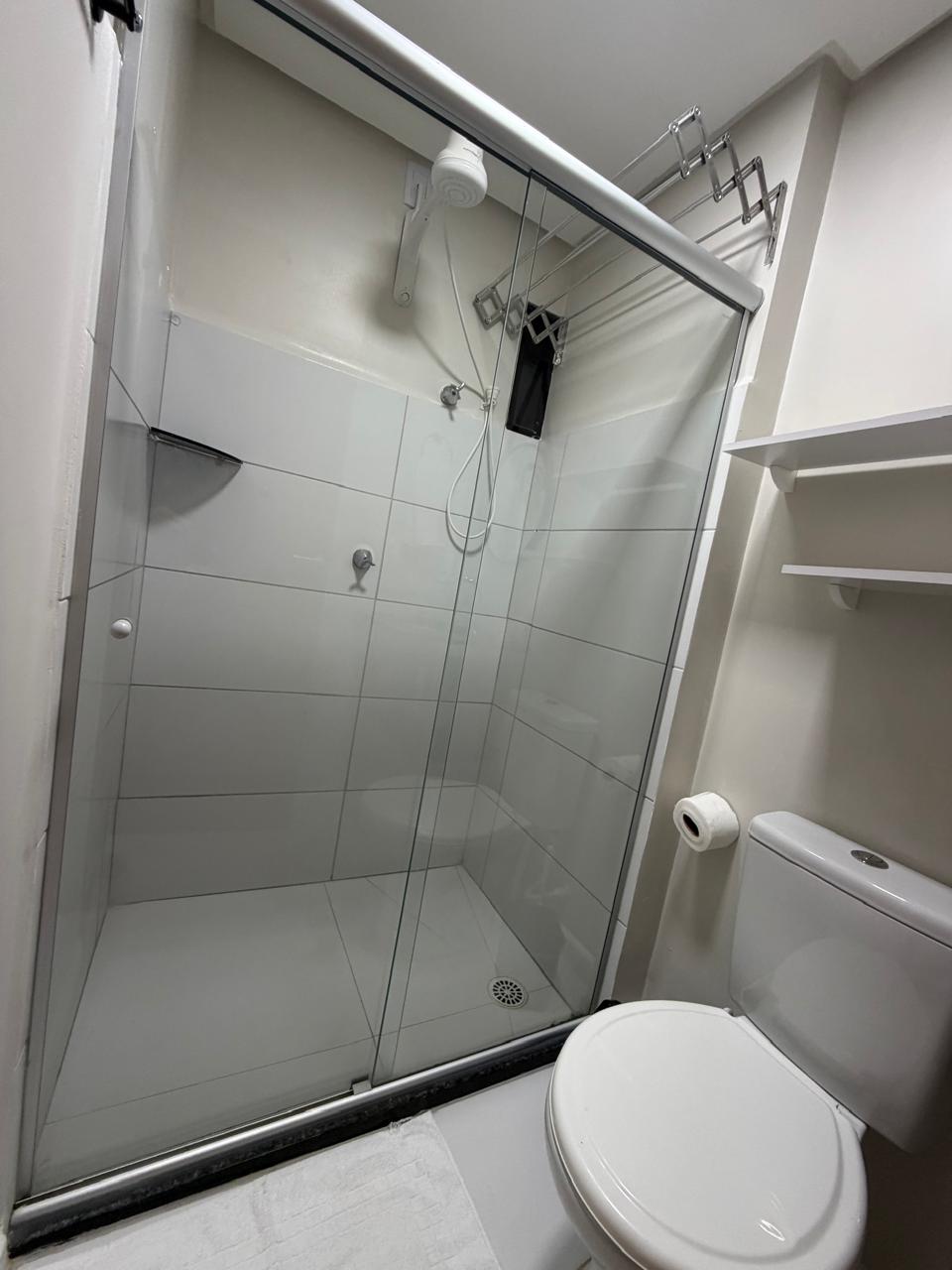 Banheiro com box de vidro e chuveiro